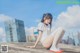 A woman sitting on top of a cement wall.