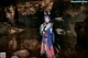 A woman in a kimono standing in a cave.