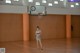 A woman in a gray dress standing on a basketball court.