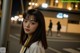 A woman standing in the middle of a street at night.