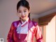 A woman in a pink kimono posing for a picture.