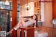 A woman sitting on top of a kitchen counter next to a washing machine.