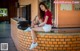 A woman sitting on a brick wall with her legs crossed.