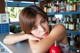 A woman leaning on a counter in front of a bar.