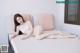 A naked woman laying on a white couch.