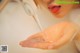 A woman is washing her hands under a faucet.