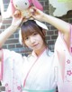 A woman in a kimono holding a stuffed animal.