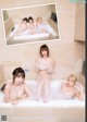 A group of young women taking a bath in a bathtub.